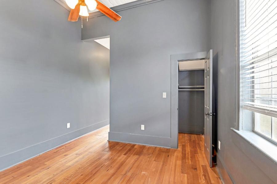 Bedroom with gray walls, closet and hardwood floors