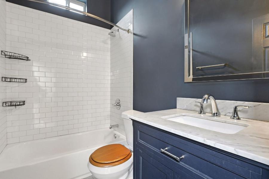 Bathroom with subway tile tub surround and navy vanity