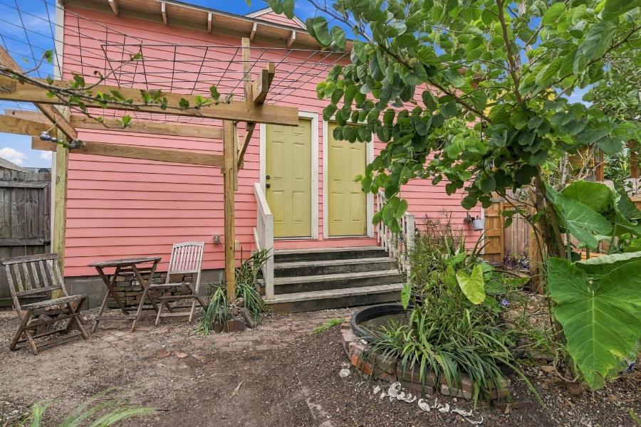 Back of the house with steps, bistro table and garden
