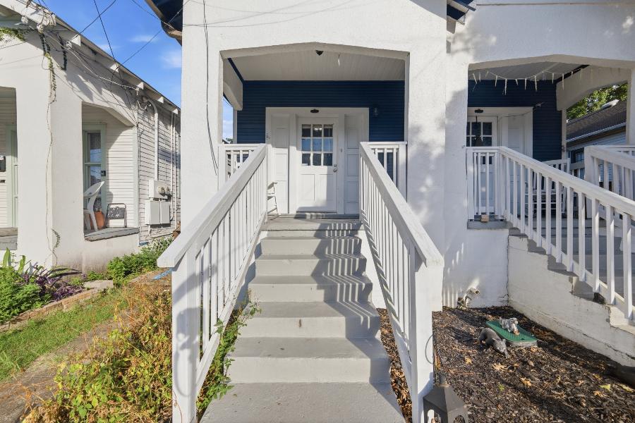 Covered front porch with white railings and steps