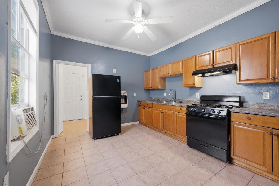 Kitchen with wood cabinets, gas range and refrigerator