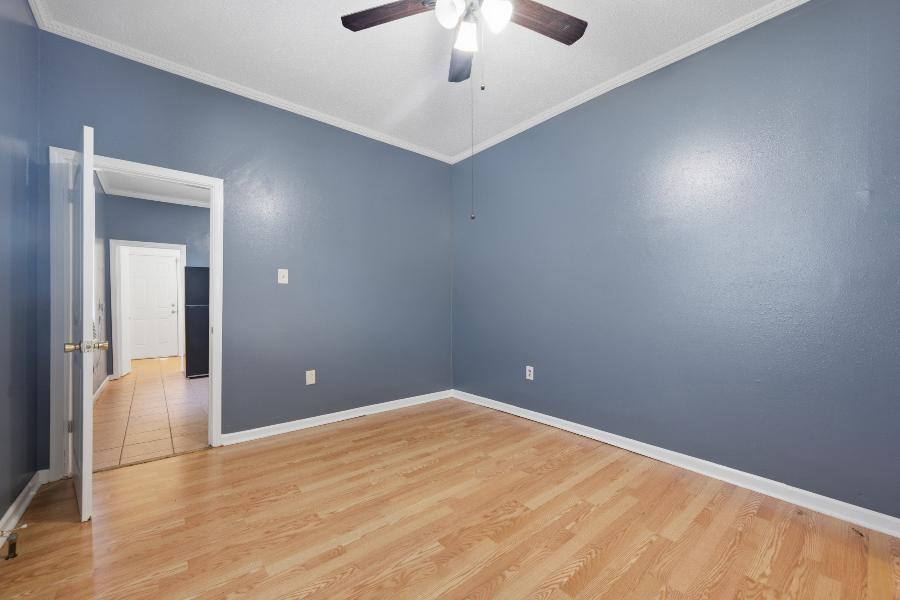 Second bedroom with ceiling fan and laminate wood floors