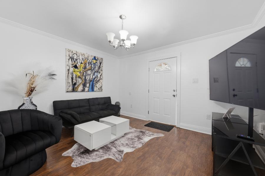 Furnished living room with sofa, swivel chair and New Orleans artwork