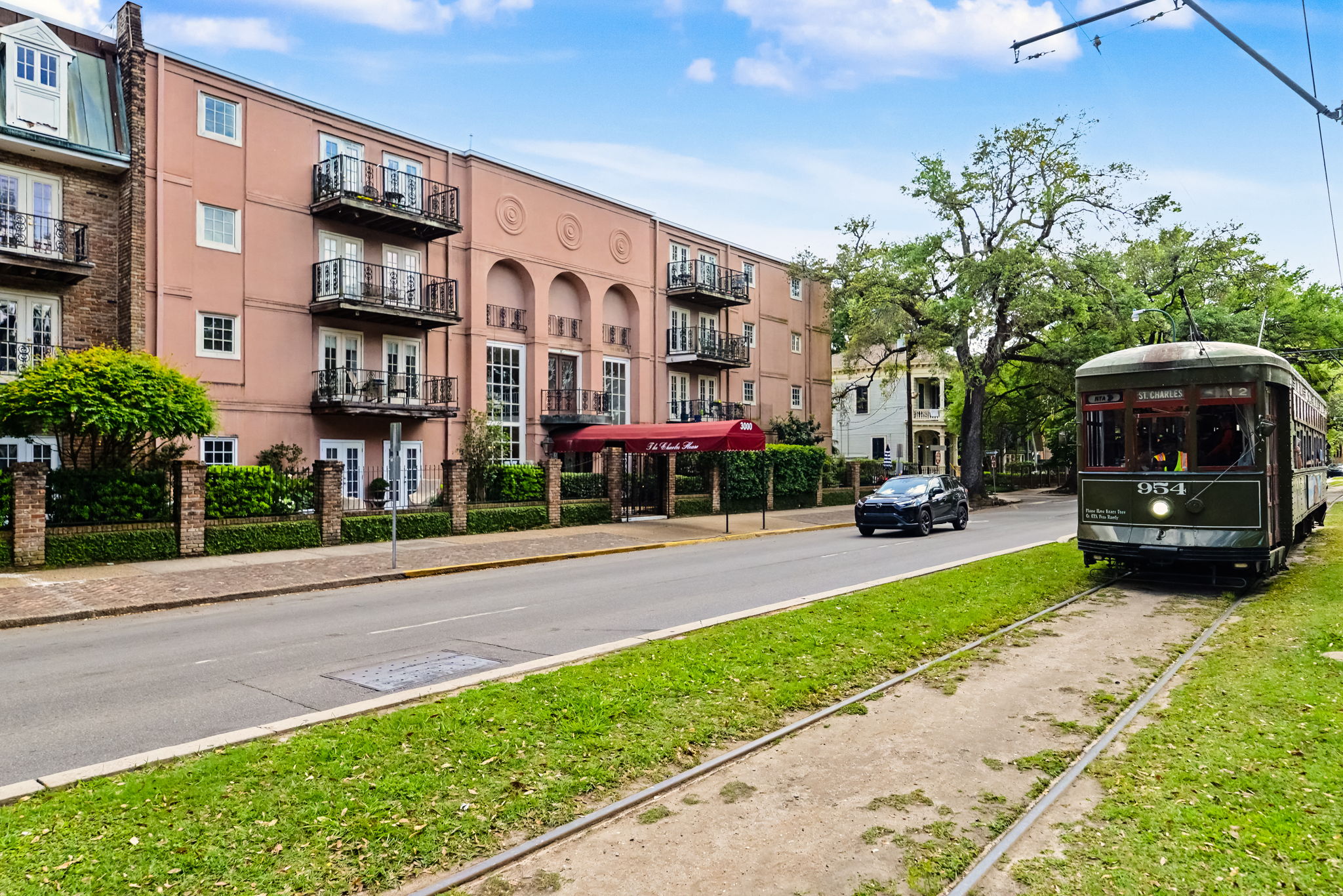 The St. Charles Avenue streetcar passing historic Uptown New Orleans apartment buildings