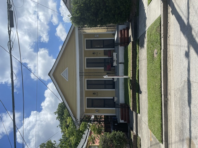 Cheerful yellow double shotgun home with twin front porches in New Orleans